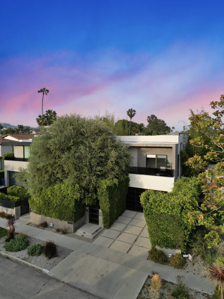 Modern architectural exterior of the 4-bedroom villa surrounded by mature hedges.