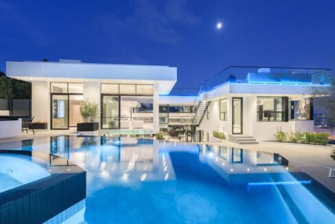 Shimmering blue resort-style pool centerpiece bordered by manicured modern grounds.