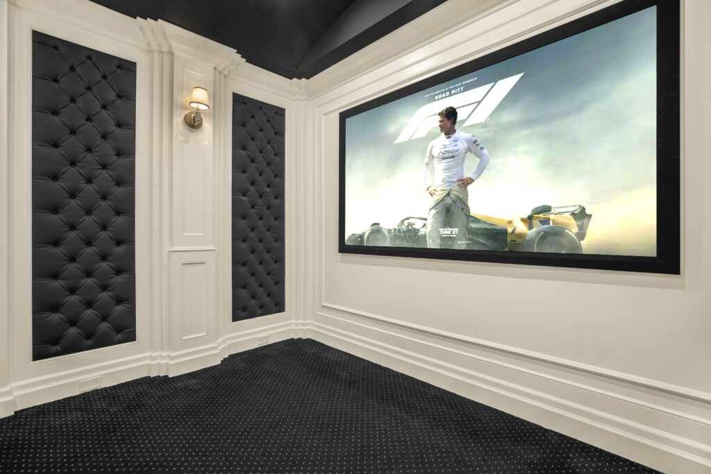 Private luxury home theater room with wide projector screen inside the villa.