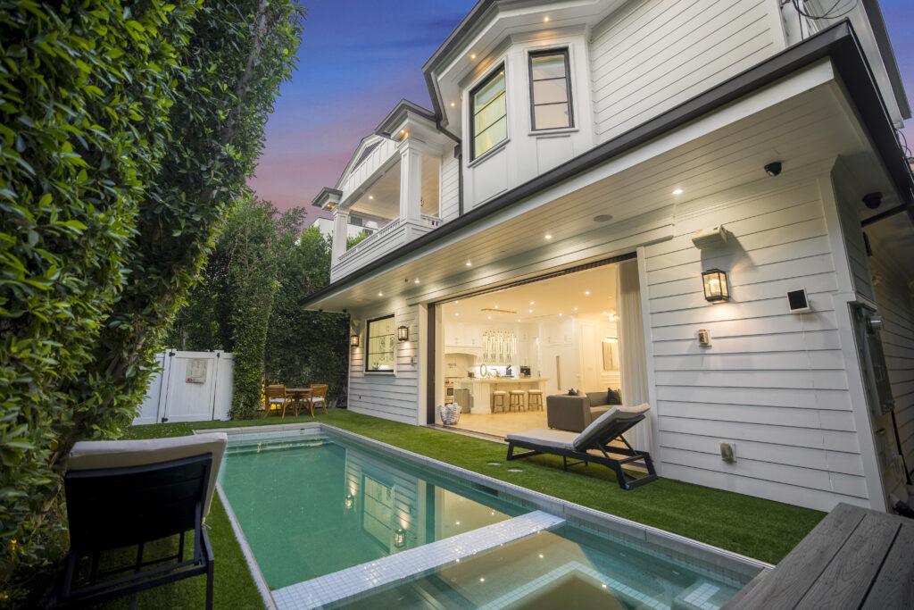 Stunning backyard pool deck and estate exterior at dusk.