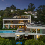 Magical twilight exterior shot of the multi-tiered luxury mansion.
