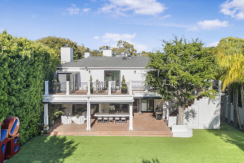 Rear view of the grand luxury estate overlooking the southern California pool deck.