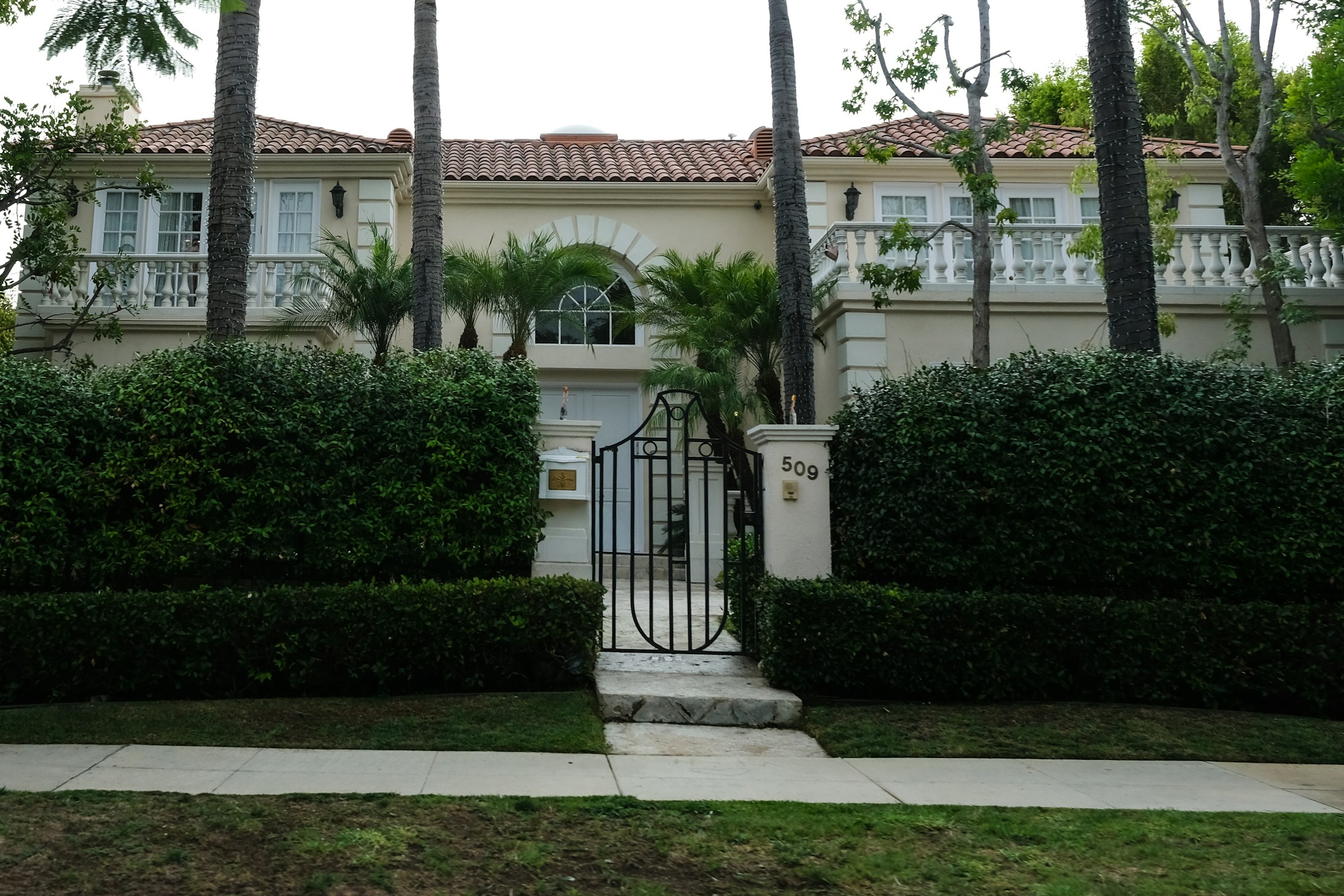 Elegant single-storey Los Angeles house with manicured hedges and palm trees
