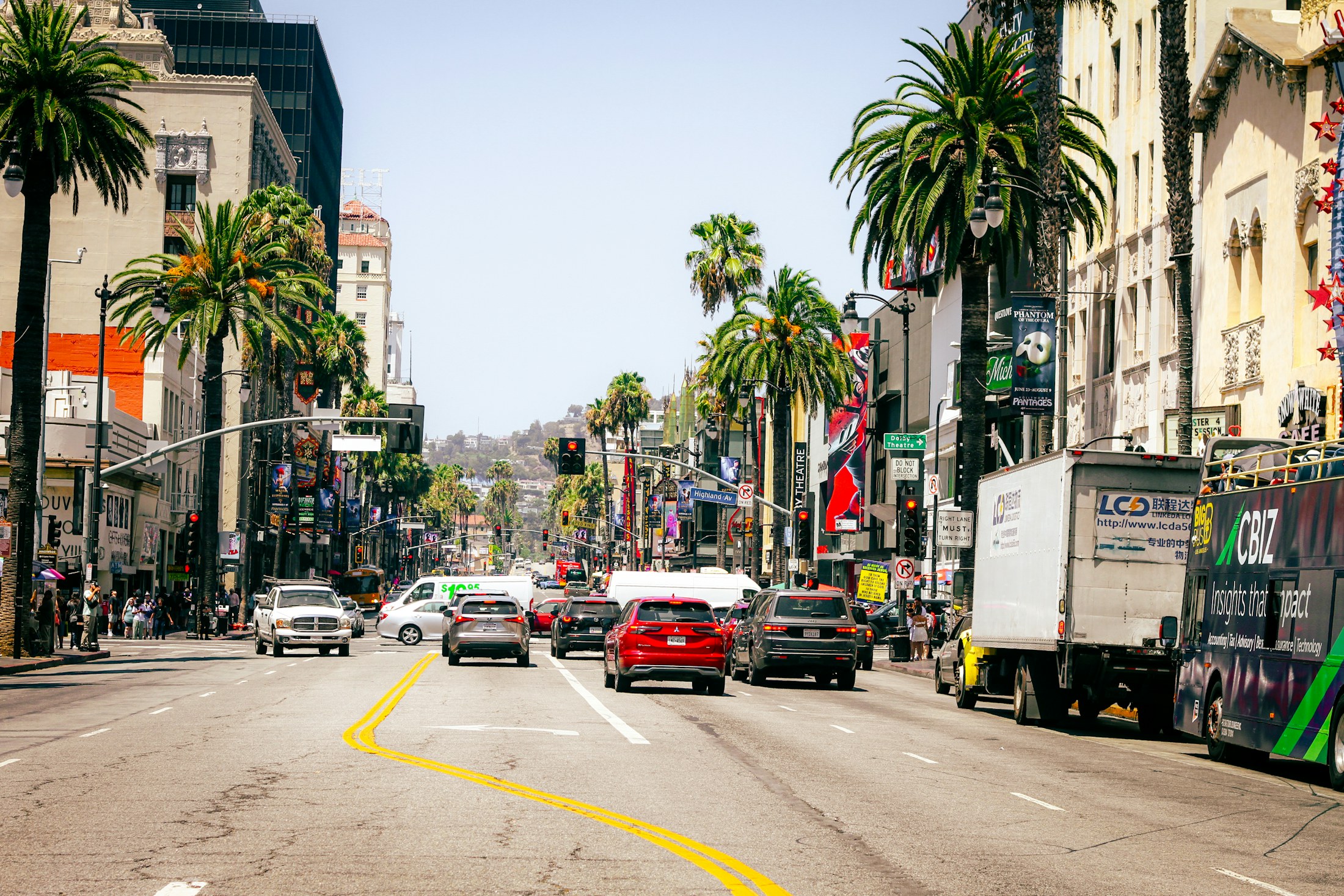 Traffic on a palm-lined boulevard in Los Angeles on a clear day